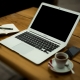Laptop, Cafetasse und Schreibblock
